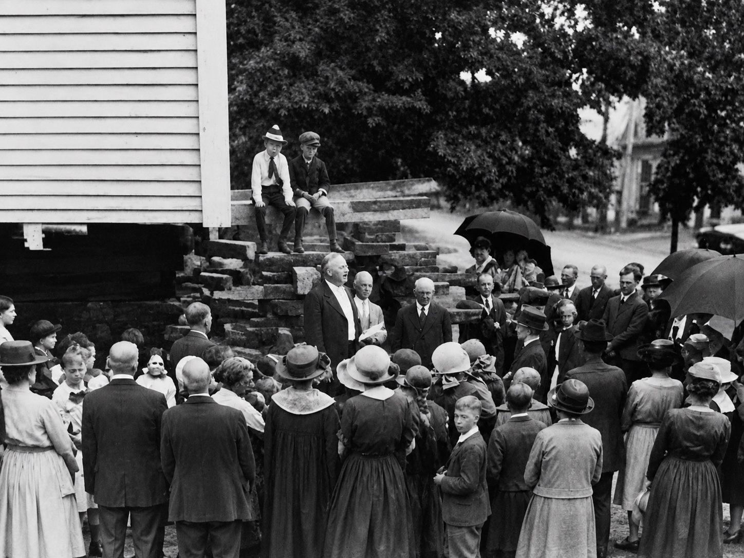 A large congregation gathered outdoors beside the church
