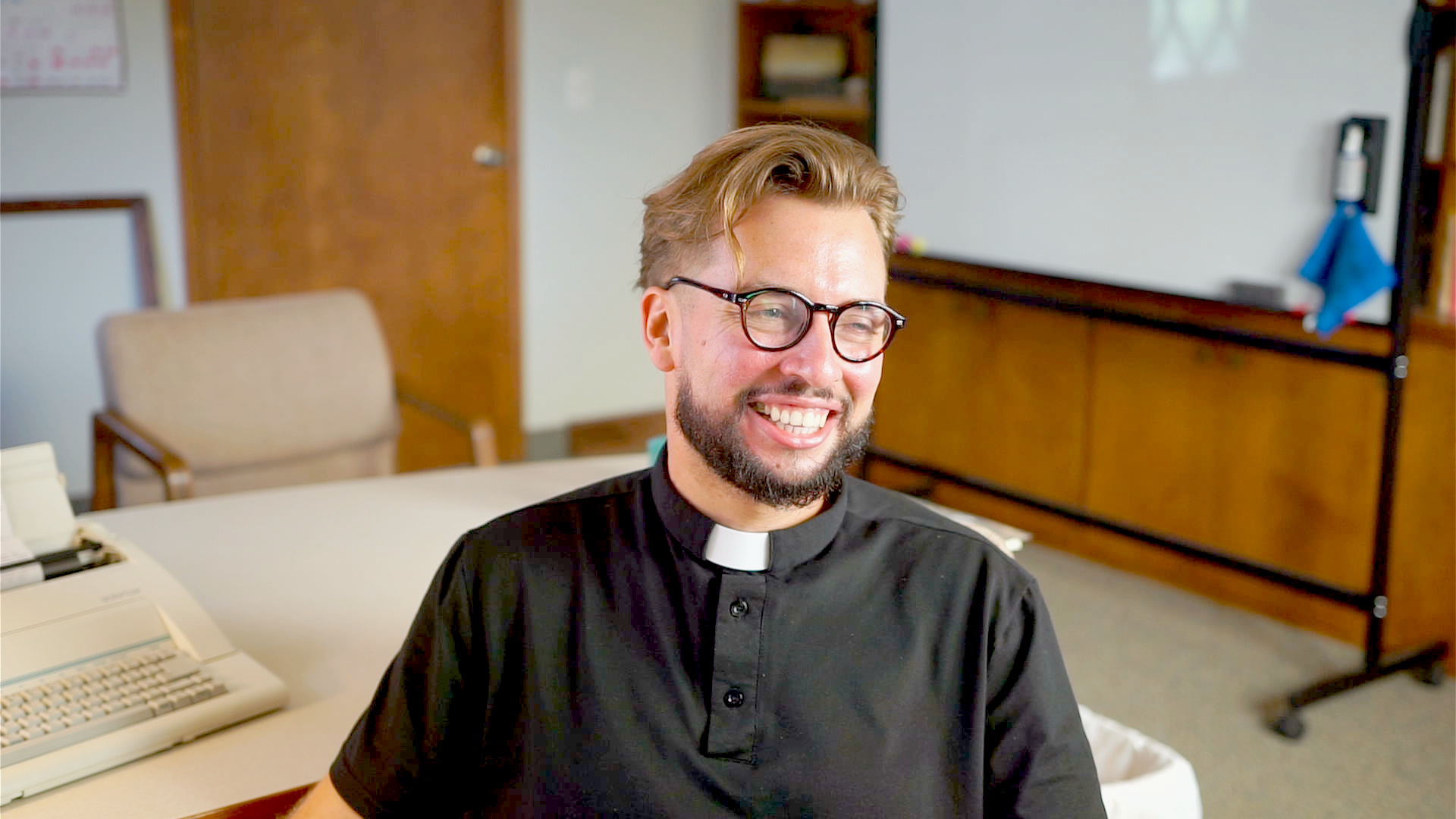 Pastor Russell Aspinwall smiling in his office